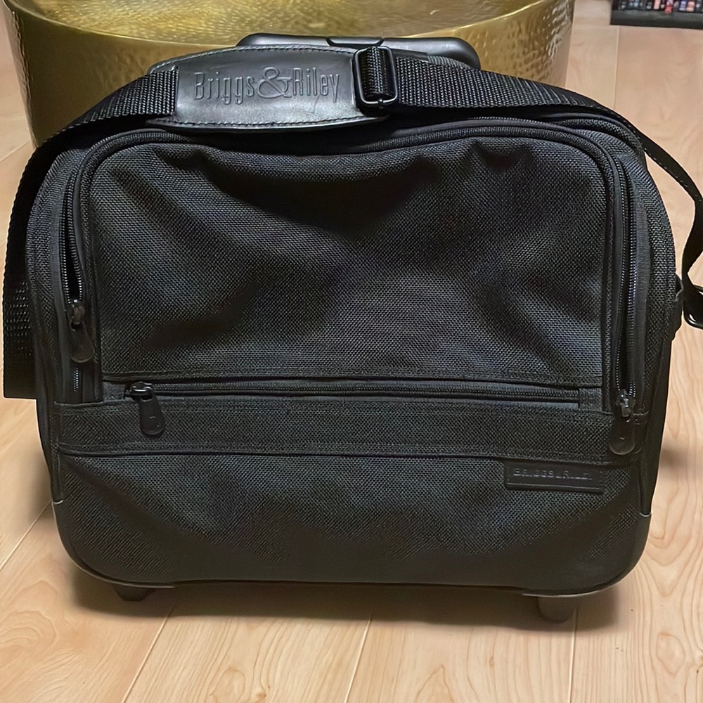 Briggs and Riley rolling bag. Has waterproof pocket for wet stuff.